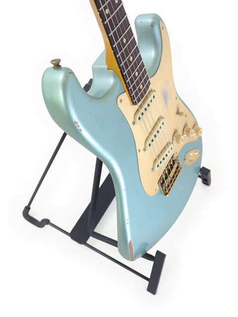Fender Custom Shop Ltd Poblano Partscaster guitar in blue on a stand, set against a simple white background.
