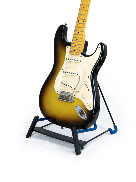Fender Custom Shop Time Machine 58 Strat Relic guitar on a stand against a clean white background, showcasing its vintage design.