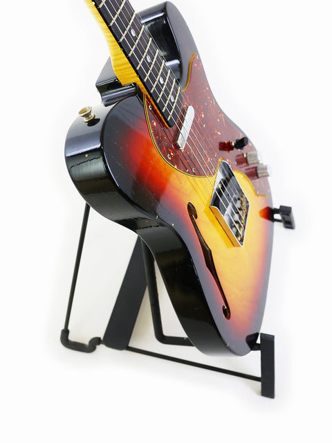 Fender Limited Edition ’60s Telecaster Thinline guitar displayed on a stand with a simple white backdrop.

