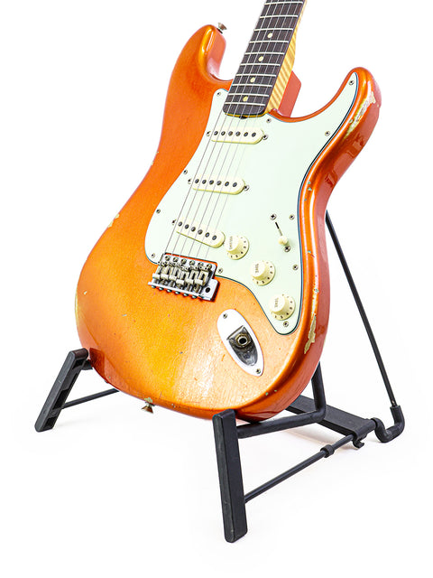 Fender Ltd NAMM '64 Stratocaster Relic guitar positioned on a stand with a stark white backdrop.