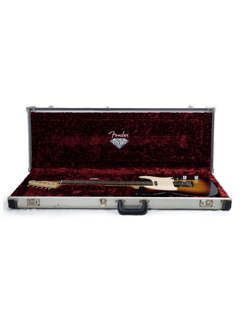 Fender guitar in a hard case with plush red interior.