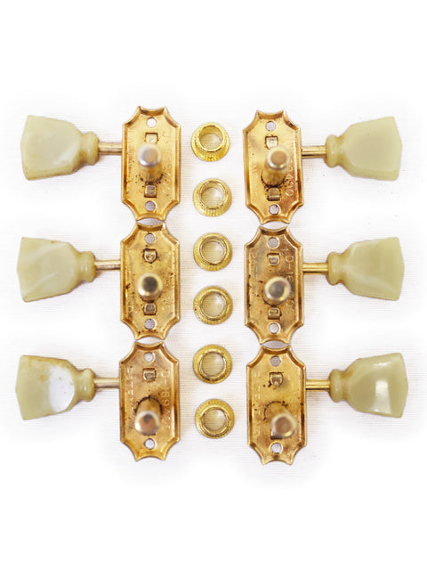 Four brass knobs with white buttons, representing the classic style of original 1960 Kluson Tulip Button Tuners.

