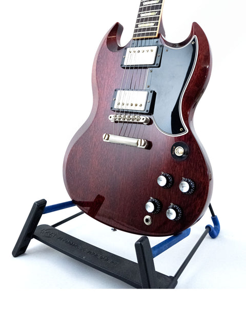 Gibson Custom ’61 Les Paul SG Standard guitar displayed on a stand featuring a stylish black base, highlighting its craftsmanship.