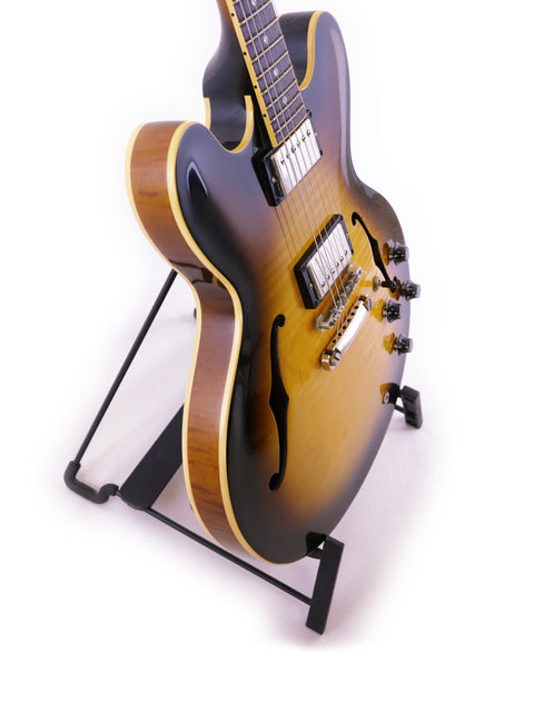 Gibson ES-335 Nashville guitar from 2006 rests on a stand, highlighted by a striking black background.