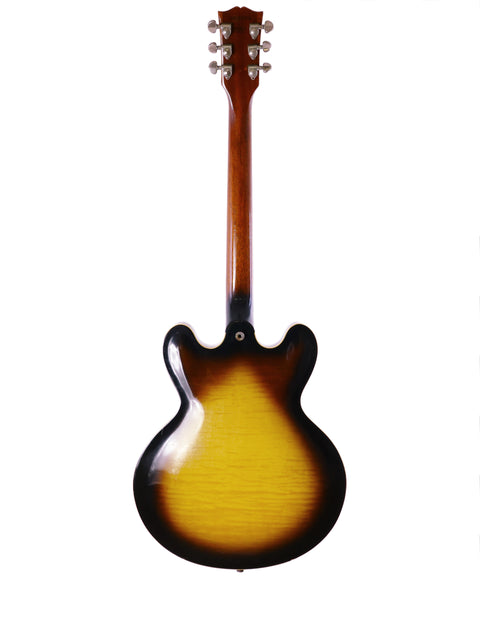Gibson ES-335 guitar with a striking sunburst finish, set on a pristine white backdrop, from the year 2006.