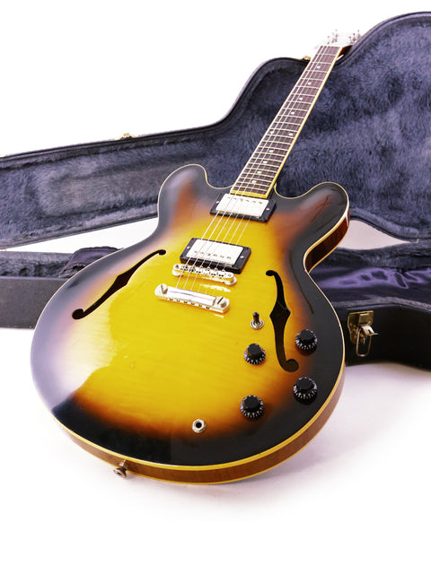 Gibson ES-335 guitar with a sunburst finish rests in its case, showcasing its elegant design and craftsmanship.
