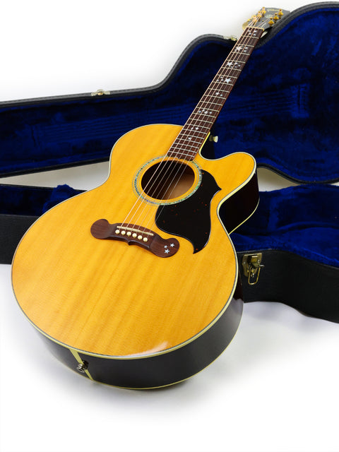 Gibson J-180EC guitar in a case, covered with luxurious blue velvet, showcasing its elegant design from 2001.

