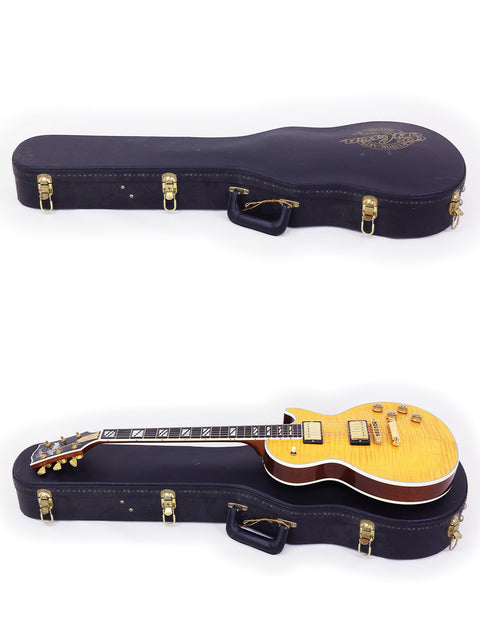 Gibson Les Paul Supreme 2003 and another guitar resting in a sturdy case, showcasing their elegant design.