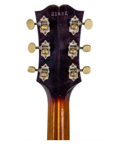 Gold headstock of a vintage 1962 Guild F-40 Valencia concert guitar, emphasizing its unique and elegant style.