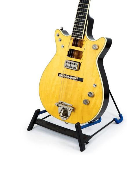 Gretsch G6131 Malcolm Young Signature Jet guitar displayed on a black stand, showcasing its sleek design and craftsmanship.
