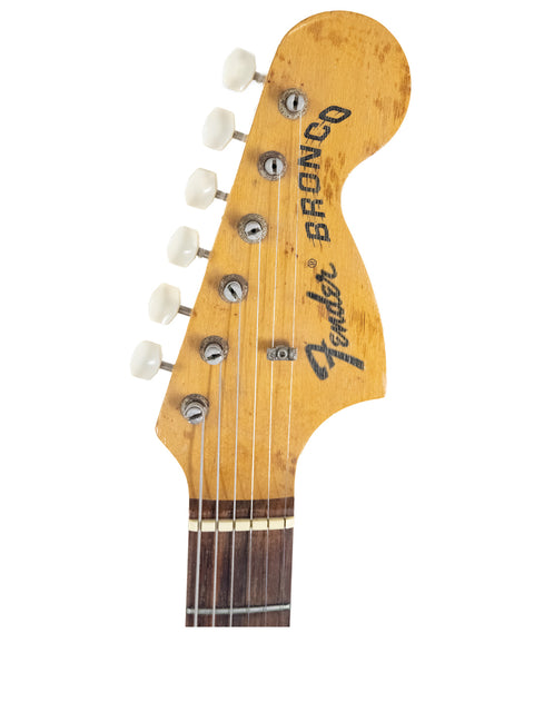 Headstock of a 1976 Fender Bronco electric guitar, clearly showing the classic Fender name.
