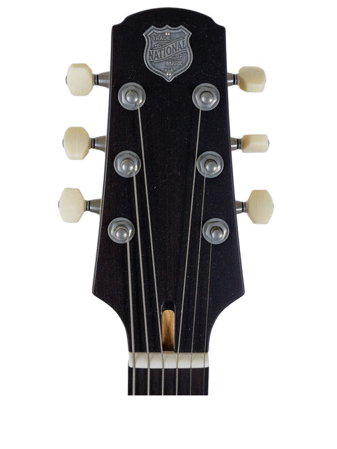 Headstock of a 2009 National Reso-Phonic Polychrome Tricone Resonator guitar featuring a distinctive badge.