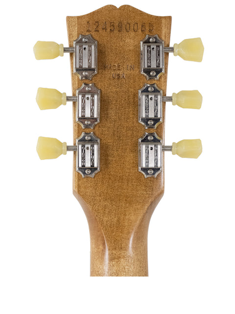 Headstock of a Gibson Les Paul Tribute electric guitar featuring four control knobs, showcasing its sleek design and craftsmanship.