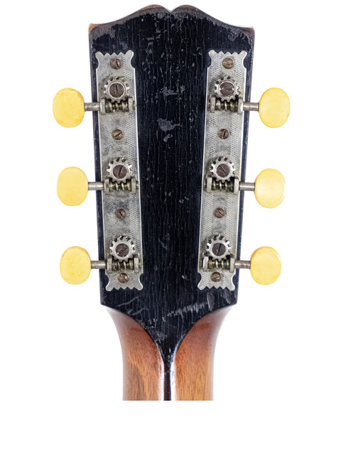 Headstock of a Vintage Gibson Style O guitar, USA 1907, with four knobs highlighting its timeless design.