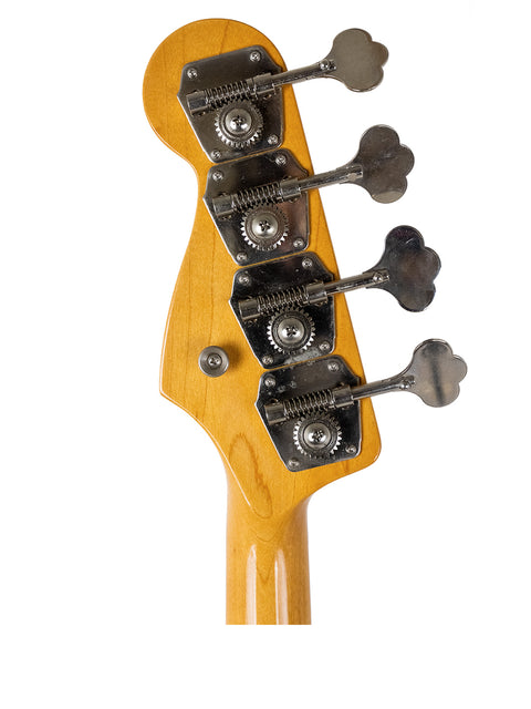 Headstock of a bass guitar with tuning pegs on a white background.