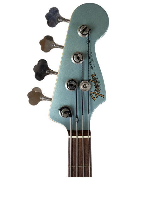 Headstock of a blue Fender guitar with tuning pegs and logo visible.