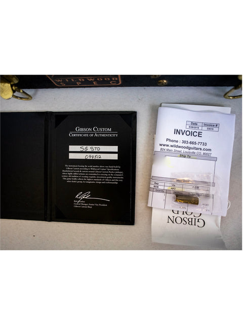 Inside a black briefcase, a receipt and a black wallet rest, alongside the Gibson Custom Shop Wildwood Spec 1961 SG Standard.
