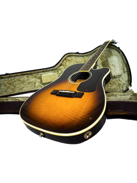 Inside a case, a 1984 Washburn Mirage Deluxe guitar gleams with a rich sunburst finish, a true vintage gem.
