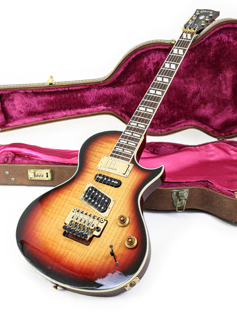 Inside a case, a 1997 Gibson Nighthawk guitar is displayed, highlighting its elegant shape and rich finish.
