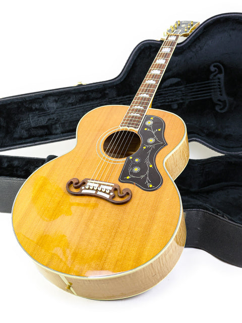 Inside a case, a 2001 Gibson SJ-200 guitar is displayed, emphasizing its classic style and secure storage.