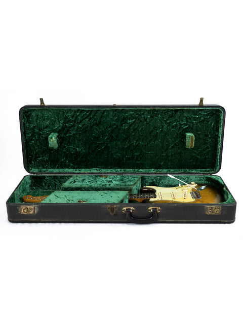 Inside a green and black guitar case lies a vintage 1963 USA L Series Stratocaster guitar.