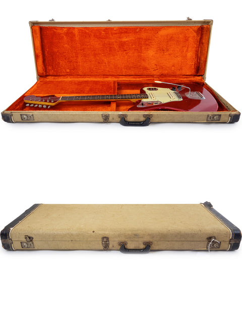 Inside a guitar case, a 1964 Candy Apple Red Fender Jaguar guitar is showcased, highlighting its vintage charm.