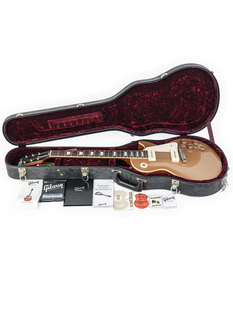 Inside a guitar case, a Gibson Les Paul LPR-4 1954 Reissue rests, surrounded by essential accessories.