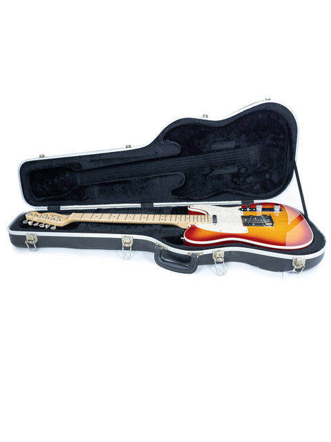  Inside a guitar case, a striking orange and black Fender American Deluxe Telecaster from 2007 is prominently displayed.