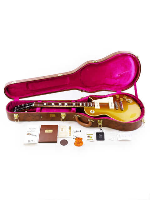 Inside a guitar case, a vibrant yellow Gibson Custom guitar gleams, highlighting its iconic Gold Top finish.