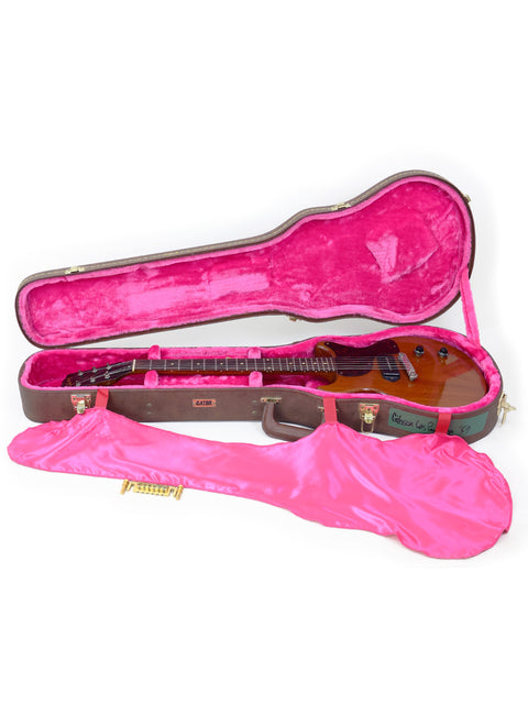 Inside a pink-lined case, a 1959 Vintage Gibson Les Paul Jr guitar stands out with its striking color and classic design.