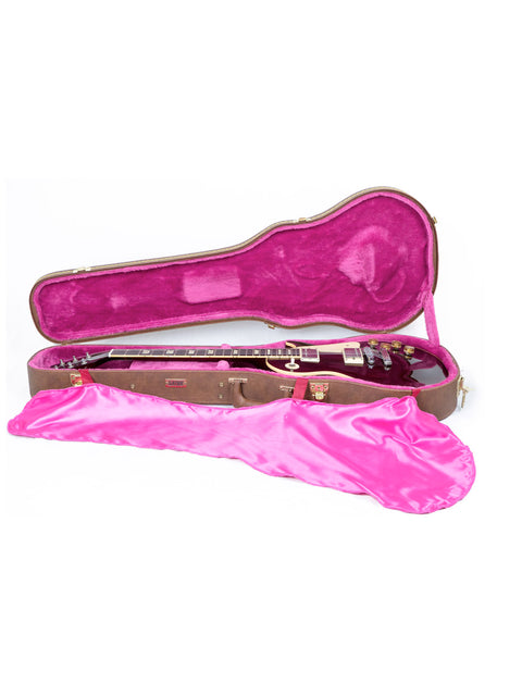 Inside a pink case lies a 1991 Gibson Les Paul Standard guitar, highlighting its iconic shape and rich craftsmanship.