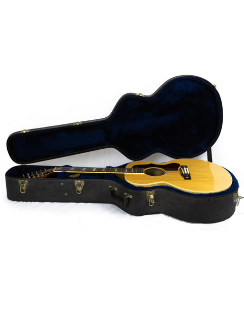 Inside a stylish guitar case lies a Gibson J-185-12 string guitar, highlighting its classic shape and rich wood finish.