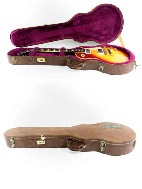 Inside a vibrant purple guitar case lies a Gibson Les Paul Standard from 1998, highlighting its iconic shape and color.