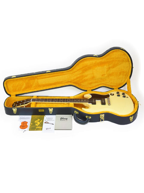Inside a white guitar case, a vibrant yellow lining highlights the Gibson Custom ‘63 SG Special, crafted in the USA, 2020.