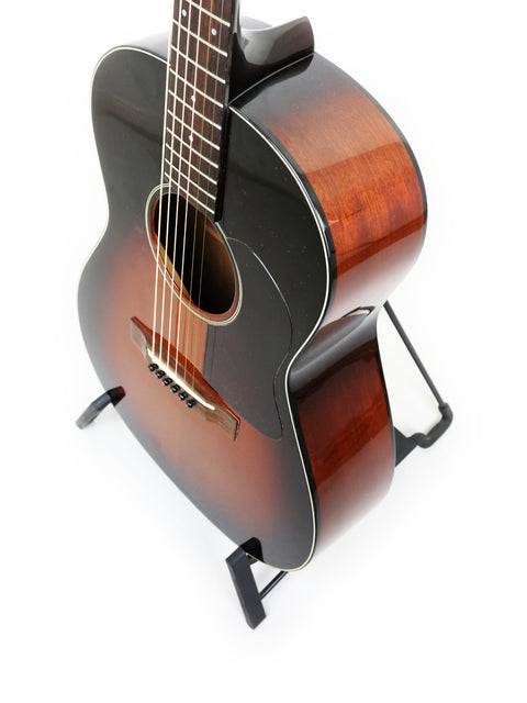  K. Yairi G-1F guitar on a stand, featuring a minimalist white background, representing its Japanese artistry from 2005.