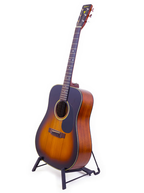 K. Yairi W1S guitar, made in Japan in 1983, resting on a stand with a white backdrop.
