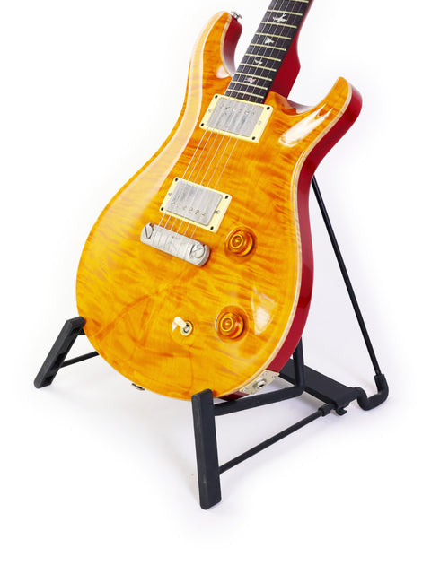 PRS Custom 22 guitar on a stand, featuring a pristine white background that highlights its stunning features and finish.
