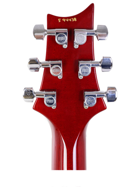 PRS Custom 22 headstock in red, 2005 model, with four knobs and a single pickup prominently displayed.