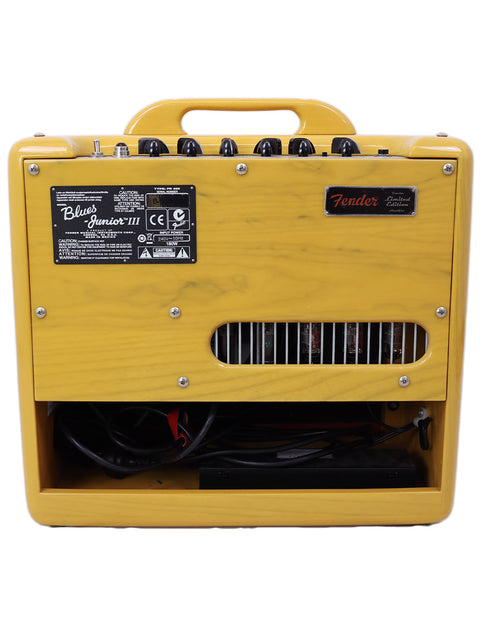Rear view of a yellow Fender guitar amplifier showing control knobs and internal components.