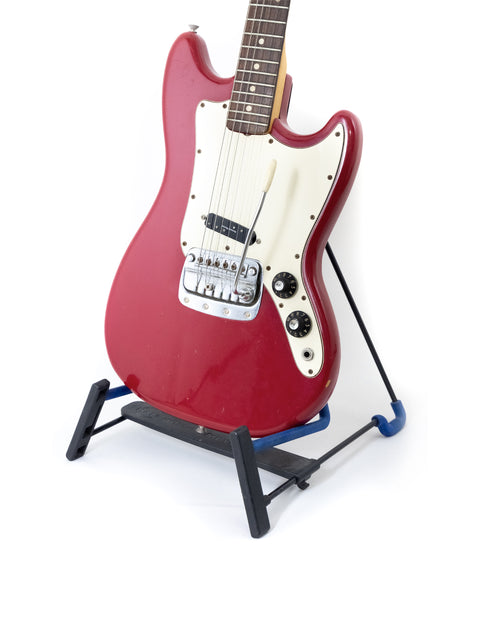 Red 1976 Fender Bronco electric guitar on a stand featuring a blue base, showcasing its vintage design.