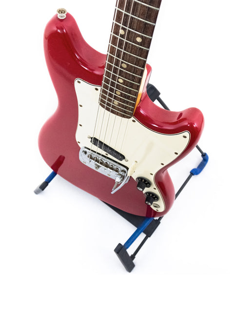 Red 1976 Fender Bronco electric guitar resting on a blue stand, showcasing its vintage design.