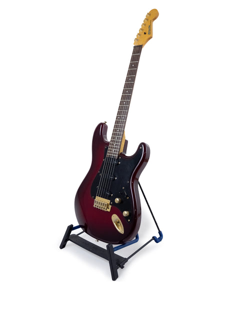 Red Levinson Blade R2 Strat guitar displayed on a black stand, highlighting its classic 1989 Japanese craftsmanship.