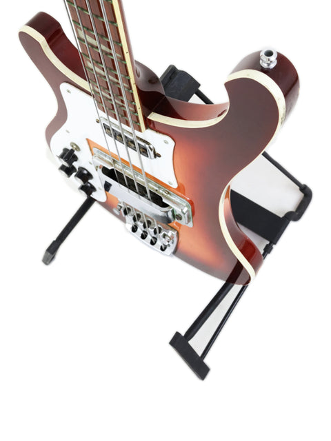 Rickenbacker 4003 Fireglo bass guitar displayed on a stand with a bright white backdrop.