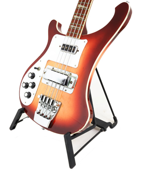 Rickenbacker 4003 Fireglo bass guitar displayed on a stand with a white backdrop.