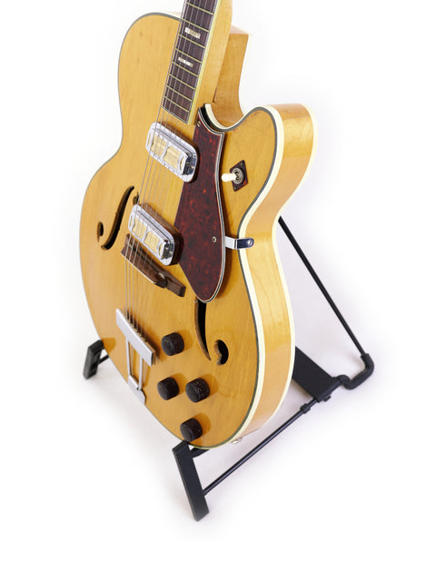 Stunning Harmony H71 Meteor guitar on a stand, highlighting its vintage charm with a crisp white background for a striking look.