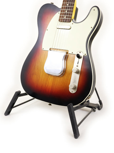 Sunburst Txxx Custom Style Partscaster guitar displayed on a stand with a simple white backdrop.