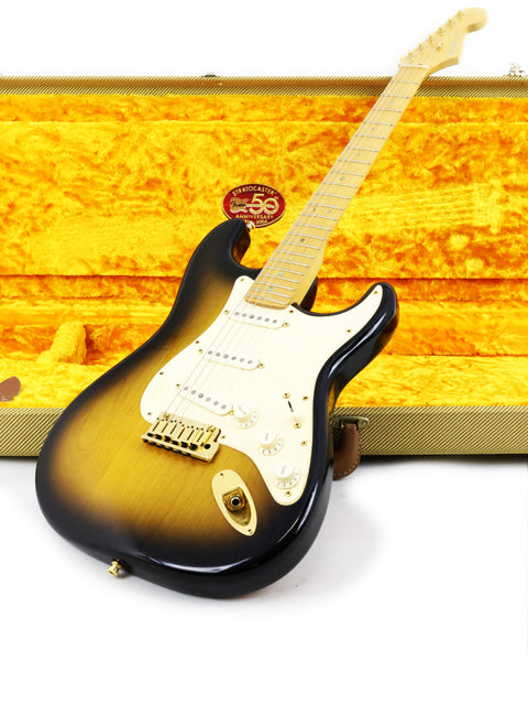Sunburst electric guitar leaning against a furry yellow guitar case.