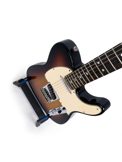Sunburst electric guitar on a stand against a white background.