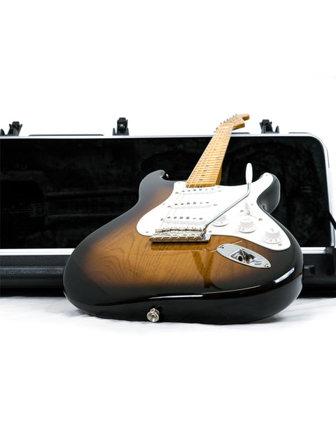 Sunburst electric guitar with white pickguard, leaning against an open black case.