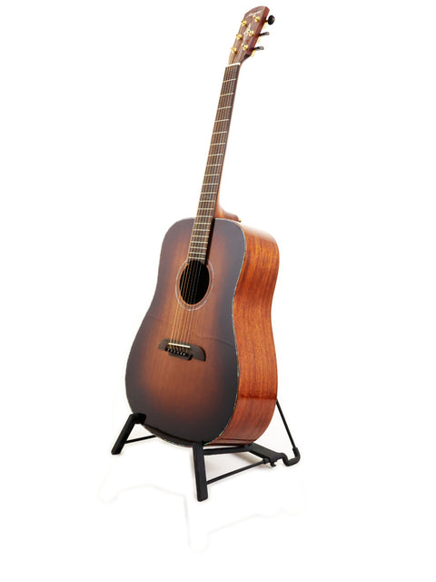 The 2019 Alvarez MDA66SHB guitar rests on a stand, showcasing its design against a bright white backdrop.